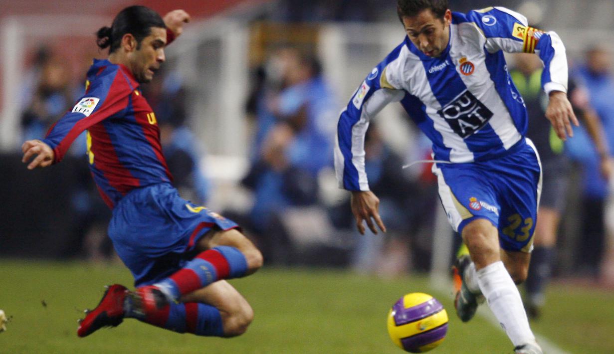 Bek Barcelona, Rafael Marquez, berusaha merebut bola dari pemain Espanyol, Raul Tamudo, pada laga La Liga di Camp Nou, Sabtu (13/12/2014). Eks bintang Barcelona ini mendapat sanksi dari Departemen Keuangan AS karena kasus narkoba. (AFP/Lluis Gene)