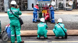 Jurnalis foto berseragam warna hijau mengabadikan kawasan kilang pengolahan minyak Pertamina (RU V) di Balikpapan, Kalimantan, Kamis (14/5). Di kawasan tersebut mereka tidak diperbolehkan membawa ponsel. (Liputan6.com/Fery Pradolo)