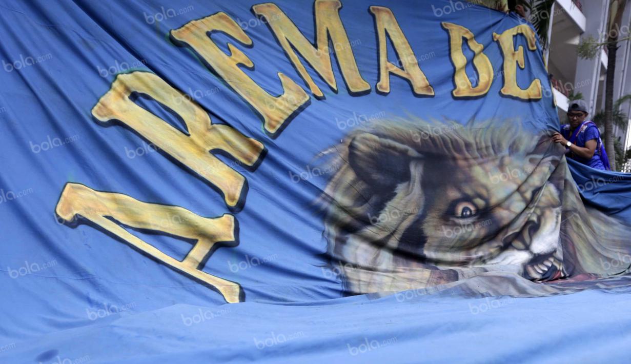 Suporter Aremania memasang spanduk di depan kantor PSSI untuk mendukung timnya berlaga pada final Torabika Bhayangkara Cup 2016 di Stadion Utama Gelora Bung Karno, Jakarta, Minggu (3/4/2016). (Bola.com/Nicklas Hanoatubun)