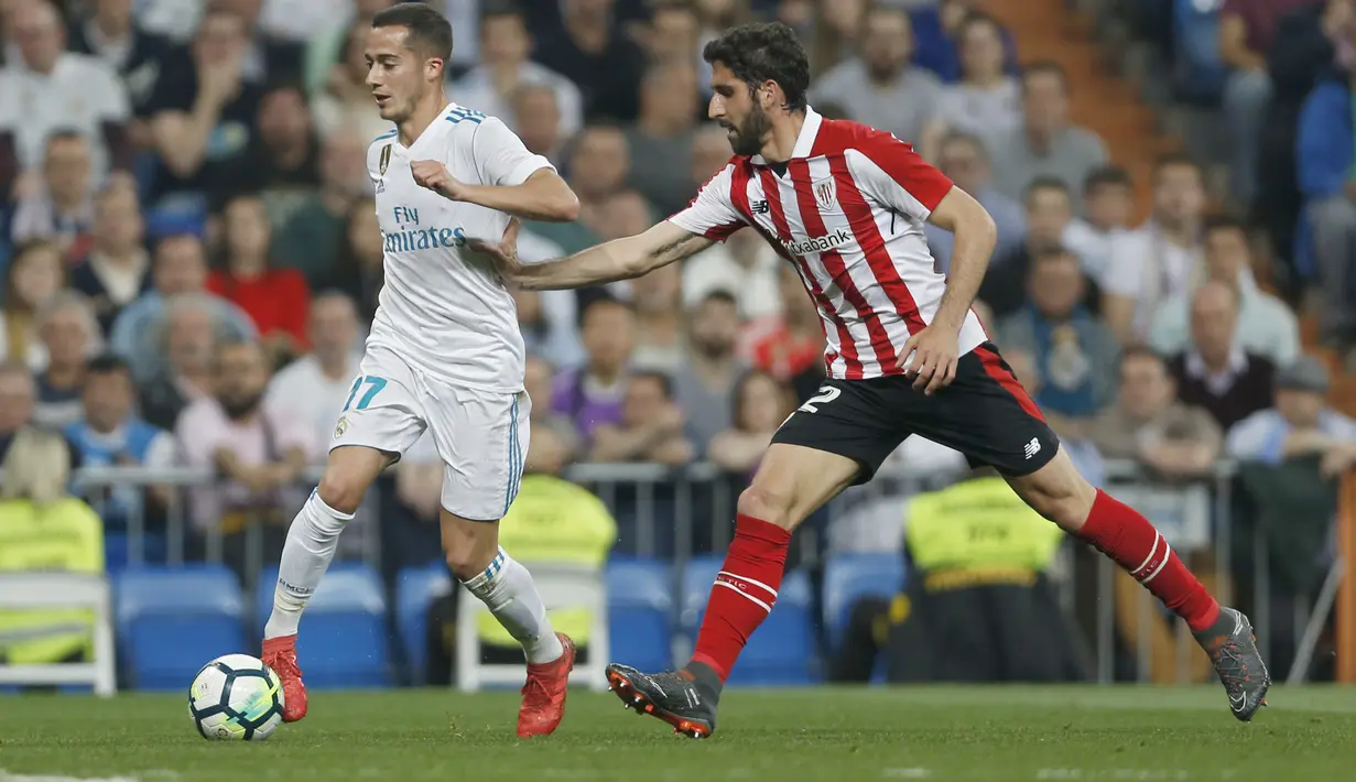 Pemain Real Madrid, Lucas Vazquez (kiri) mengecoh pemain Athletic Bilbao, Raul Garcia pada lanjutan La Liga Santander di Santiago Bernabeu stadium, Madrid, (18/4/2018). Real Madrid bermain imbang 1-1 dengan Bilbao. (AP/Francisco Seco)