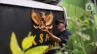 Warga memasang lambang burung Garuda Pancasila di sebuah tembok di di Kampung Pancasila, Karang Tengah, Kota Tangerang, Selasa (1/6/2021). Sejumlah kegiatan diadakan warga, Komunitas Taman Potret dan TNI ini untuk memperingati Hari kelahiran Pancasila. (Liputan6.com/Angga Yuniar)