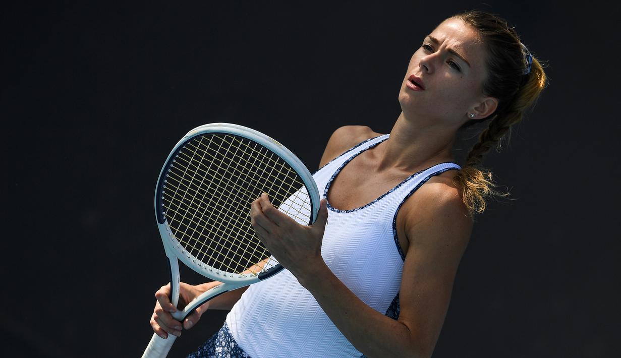 Petenis Italia, Camila Giorgi, memegang raket saat melawan petenis Jerman, Antonia Lottner, pada laga Australia Open di Melbourne, Selasa (21/1). (AFP/Greg Wood)