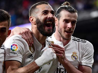 Striker Real Madrid, Karim Benzema, merayakan gol yang dicetaknya ke gawang Huesca pada laga La Liga Spanyol di Stadion Santiago Bernabeu, Madrid, Minggu (31/3). Madrid menang 3-2 atas Huesca. (AFP/Javier Soriano)