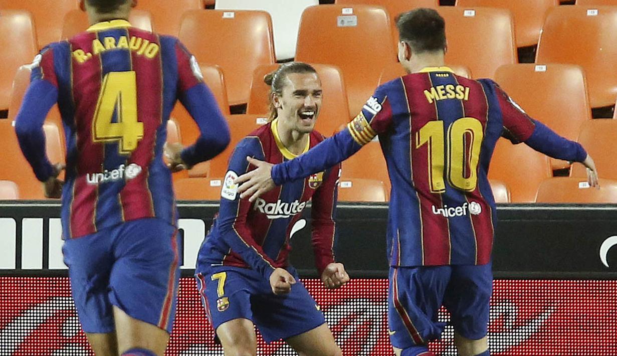 Penyerang Barcelona, Antoine Griezmann, melakukan selebrasi bersama Lionel Messi  usai mencetak gol ke gawang Valencia pada laga Liga Spanyol di Stadion Mestalla, Minggu (2/5/2021). Barcelona menang dengan skor 2-3.  (AP Photo/Alberto Saiz)