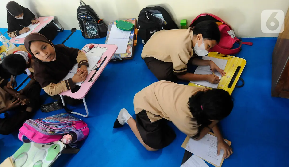 Aktivitas belajar sejumlah siswa tanpa fasilitas meja dan kursi sekolah, di SDN Bojong Nangka 02, Kabupaten Bogor, Jawa Barat, Kamis (16/2/2023). Sudah lebih dari dua pekan, murid-murid di tiga ruang kelas  menerapkan kegiatan belajar mengajar beralas karpet karena belum tersedianya bangku dan meja. (merdeka.com/Arie Basuki)