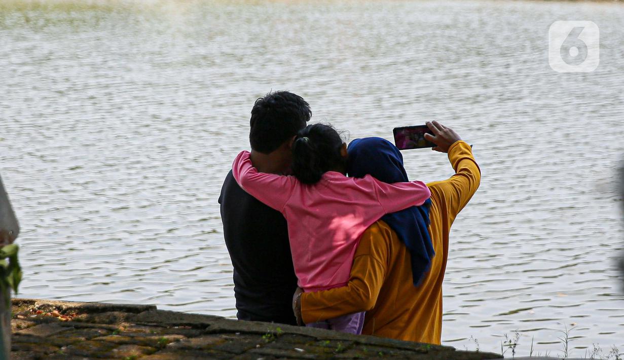Wisatawan berselfie saat mengunjungi TMII, Jakarta, Kamis (20/8/2020). Libur panjang yang bertepatan tahun baru islam di manfaatkan masyarakat bersama keluarga  berlibur ke sejumlah tempat wisata. (Liputan6.com/Faizal Fanani)
