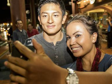 Pebalap Formula 1 asal Indonesia, Rio Haryanto, selfie bersama fans yang menyambutnya di Bandara Soekarno-Hatta, Tangerang, Senin (14/3/2016). (Bola.com/Vitalis Yogi Trisna)