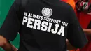 Seorang suporter Persija mengenakan kaus bertluiskan dukungan jelang menyaksikan laga Persija melawan Bali United di Stadion Patriot Candrabhaga, Bekasi, Minggu (21/5). Laga kedua tim berakhir imbang 0-0. (Liputan6.com/Helmi Fithriansyah)