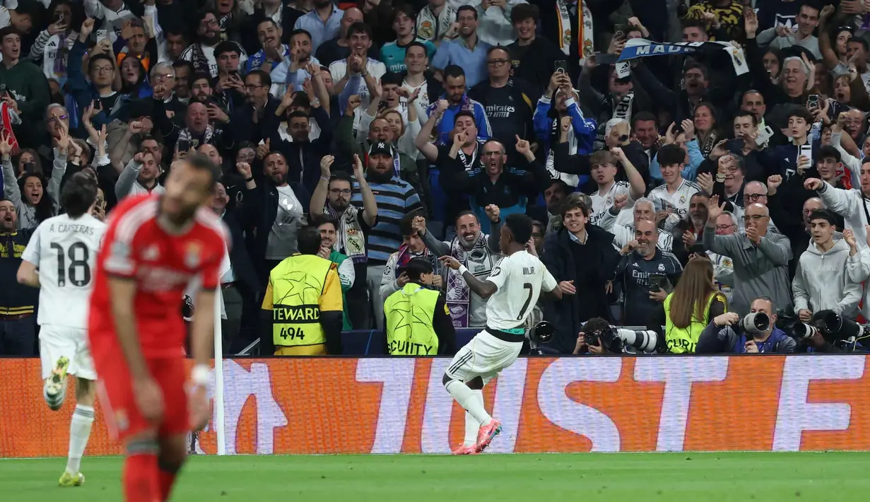 Jelang laga usai, serangan balik cepat Real Madrid dimanfaatkan dengan baik oleh Vinícius Junior, pada menit ke-80, yang mencetak gol kemenangan Los Blancos sekaligus menutup rangkaian duel dua leg tersebut. Tampak dalam foto, penyerang Real Madrid asal Brasil, Vinicius Junior, merayakan golnya selama pertandingan leg kedua babak playoff 16 besar Liga Champions 2025/2026 melawan SL Benfica di Stadion Santiago Bernabeu pada Rabu 25 Februari 2026 waktu setempat atau Kamis (26/2/2026) dini hari WIB. (Pierre-Philippe MARCOU/AFP)
