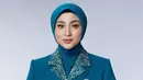 Margin tampil elegan dengan pakaian serba birunya. Terdiri dari inner kemeja batik motif bunga hijau dipadukan blazer sebagai luaran. [@aldiphotoofficial]