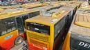 Petugas mengecek bangkai bus Transjakarta yang mangkrak di terminal Pulogadung, Jakarta, Jumat (23/8/2019). Menurut petugas, sebanyak 36 bus transjakarta yang sudah terparkir sejak Oktober 2017 tersebut berada dalam kondisi rusak dan tidak terawat. (Liputan6.com/Herman Zakharia)