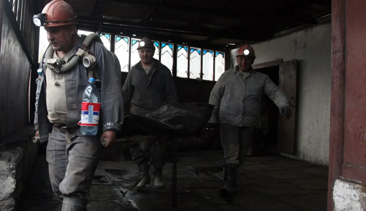 Penambang membawa tubuh salah satu korban ledakan di tambang batu bara Skochynskyy di kota Donetsk, Ukraina timur pada Jumat 11 April 2014. (AFP PHOTO/Anatoliy Stepanov)