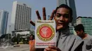 Aktivis Pemuda Untuk Keadilan dan Persatuan Indonesia (PKPI) memperlihatkan stiker yang berisikan penolakan pencalonan Sutiyoso jadi kepala BIN saat aksi damai di Bundaran HI, Jakarta, Minggu (28/6/2015). (Liputan6.com/Faizal Fanani)