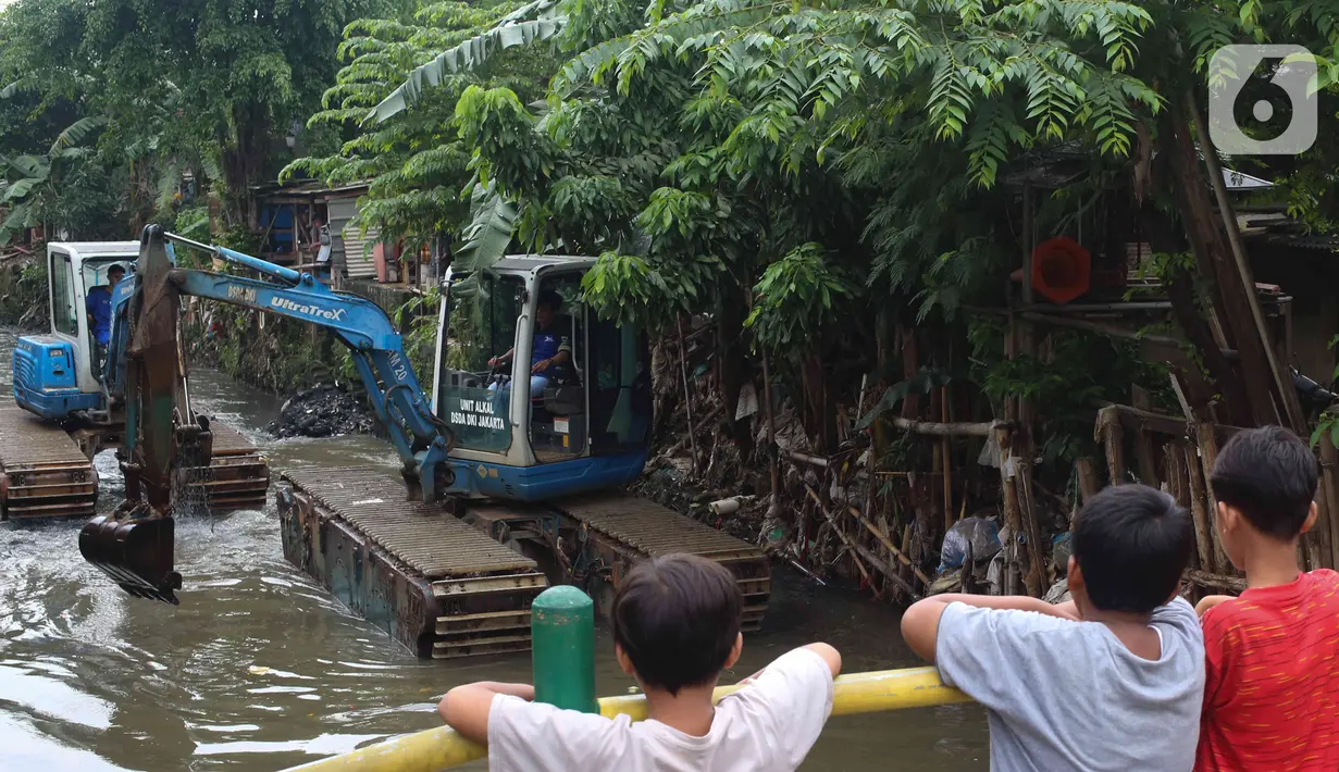 Anak-anak mengamati alat berat yang dioperasikan untuk pengerukan Kali Mampang, Pondok Jaya, Sabtu (19/2/2022). Pengadilan Tata Usaha Negara (PTUN) Jakarta mengabulkan gugatan warga pada 19-21 Februari 2021 terkait program pencegahan banjir yang dilakukan Pemprov DKI (Liputan6.com/Herman Zakharia)