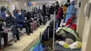Seorang perempuan merawat kerabat lansianya yang terbaring di tandu saat pasien menerima infus di bangsal darurat sebuah rumah sakit di Beijing, Kamis (5/1/2023). Pasien, kebanyakan dari mereka lansia, berbaring di tandu di lorong dan menerima oksigen sambil duduk di kursi roda saat kasus COVID-19 melonjak di ibu kota China, Beijing. (AP Photo/Andy Wong)