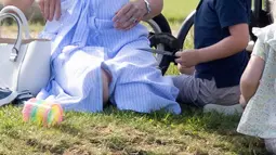 Kate Middleton terlihat mengobrol bersama Pangeran George yang sedang memamerkan sesuatu di tangannya saat menghadiri acara amal Kerajaan Inggris bertajuk Maserati Royal Charity Polo Trophy di Beaufort Polo Club, Gloucestershire, Minggu (10/6). (AP Photo)