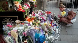 Bunga dan lilin diletakan setelah serangan bunuh diri di sebuah konser Ariana Grande di Albert Square, Manchester, Inggris, (23/5). Kepolisian Inggris menetapkan pelaku bom diri di konser Ariana Grande bernama Salman Abedi. (AP Photo/Kirsty Wigglesworth)