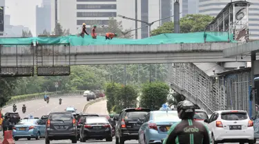 Suasana lalu lintas saat pekerja membongkar jembatan penyeberangan orang (JPO) Tosari, Jakarta, Minggu (16/12). Pembongkaran JPO Tosari ditergetkan selesai pada 20 Desember 2018. (Merdeka.com/Iqbal Nugroho)