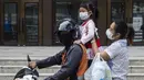 Seorang wanita bersama anaknya mengenakan masker saat menaiki motor saat kabut asap menyelimuti Bangkok (16/1). Thailand telah berupaya untuk mengatasi polusi yang telah menyelimuti ibukota dalam beberapa pekan terakhir. (AFP Photo/Romeo Gacad)