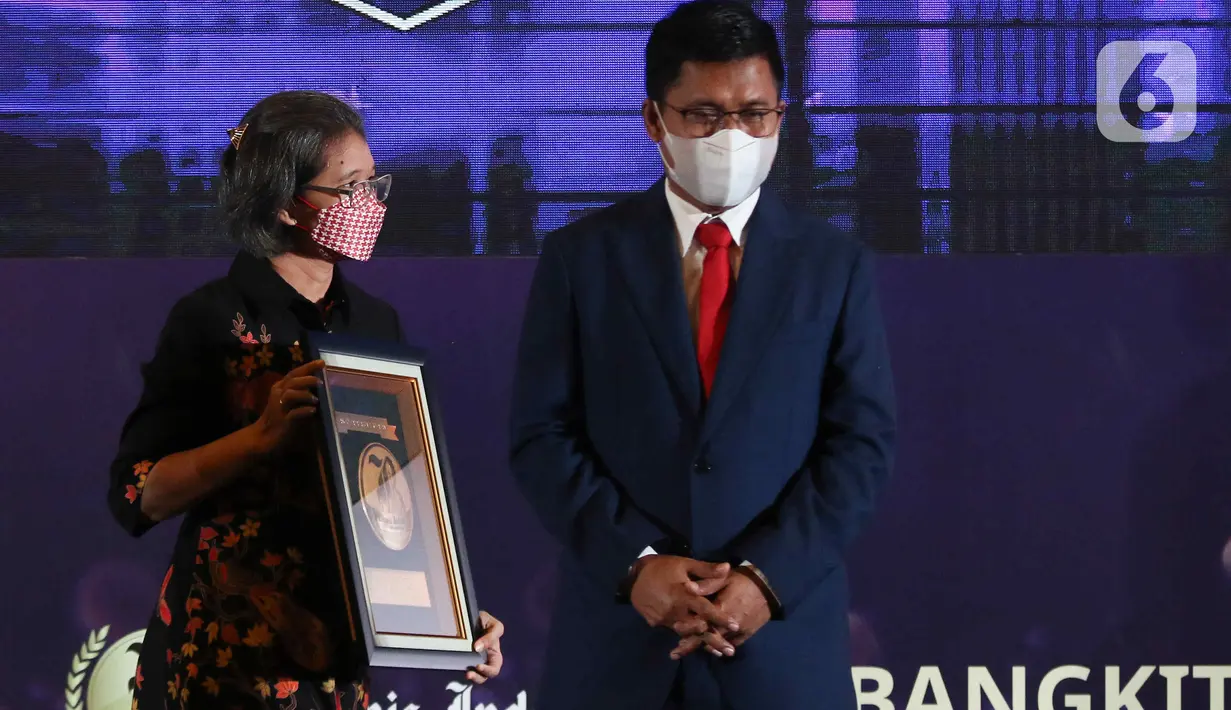 Irnawati W. Kahardja selaku Head of Protocol and Public Affairs PT Surya Citra Media Tbk, menerima piagam usai penganugerahan Bisnis Indonesia Award (BIA) 2022 di Jakarta, Senin (15/8/2022). PT Surya Citra Media TBK mendapatkan penghargaan Bisnis Indonesia Award (BIA) 2022 dalam kategori Media dan Hiburan. (Liputan6.com/Herman Zakharia)