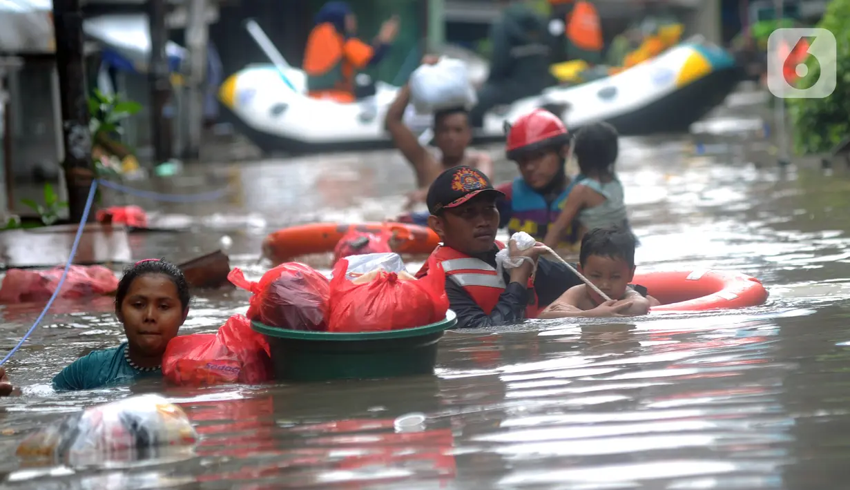 Petugas Pemadam Kebakaran mengevakuasi anak-anak korban banjir dengan menggunakan ban di kawasan Karet Pasar Baru Barat, Jakarta, Selasa (25/2/2020). Banjir yang terjadi sejak subuh akibat luapan Kanal Banjir Barat tersebut merendam ratusan rumah hingga setinggi dua meter. (merdeka.com/Arie Basuki)