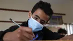 Seorang siswa yang mengenakan masker mengikuti ujian di sebuah sekolah di Sanaa, Yaman (30/8/2020). (Xinhua/Mohammed Mohammed)