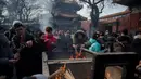 Sejumlah warga membakar dupa untuk berdoa keberuntungan pada hari kelima Tahun Baru Imlek di Yonghegong, atau Kuil Lama di Beijing (9/2). Warga China merayakan Tahun Babi tersebut dengan doa, pesta keluarga, dan belanja. (AFP Photo/Nicolas Asfouri)