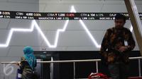Pekerja melintas di bawah layar indeks saham gabungan di BEI, Jakarta, Selasa (4/4). Sebelumnya, Indeks harga saham gabungan (IHSG) menembus level 5.600 pada penutupan perdagangan pertama bulan ini, Senin (3/4/2017). (Liputan6.com/Angga Yuniar)