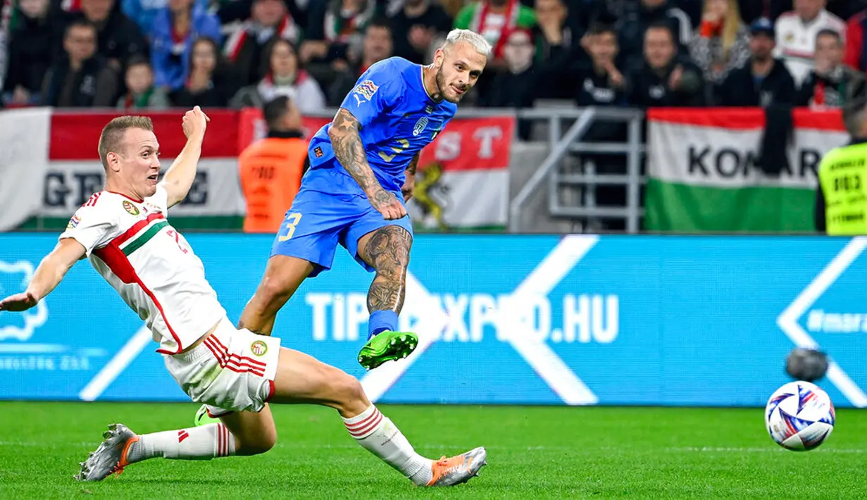 Pemain Italia Federico Dimarco (kanan) menendang bola melewati pemain Hungaria Adam Lang pada pertandingan sepak bola UEFA Nations League di Puskas Arena, Budapest, Hungaria, 26 September 2022. Italia berhasil mengalahkan Hungaria dengan skor 2-0. (Zsolt Szigetvary/MTI via AP)