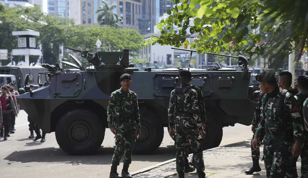 Personel Tentara Nasional Indonesia (TNI) berdiri di dekat kendaraan lapis baja yang diparkir di dekat Monumen Nasional, Jakarta, Selasa 2 September 2025. (AP Photo/Dita Alangkara)