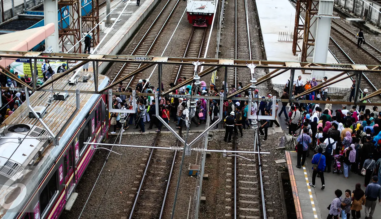 Puluhan calon penumpang melintasi rel kereta api di Stasiun Tanah Abang, Jakarta, Senin (11/7). Stasiun Tanah Abang mulai ramai di awal kerja usai libur lebaran. (Liputan6.com/Faizal Fanani)