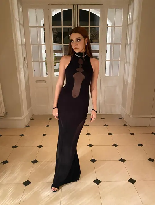 Pesona misterius Emily Carey lainnya ditunjukkan dengan menjadi cewek mamba. Ia mengenakan halter neck dress berwarna hitam dengan rambut yang digerai. (instagram/theemilycarey)