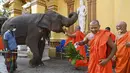 Seorang biksu menawarkan pisang kepada seekor gajah di Kuil Gangaramaya pada hari pertama prosesi Buddhis Navam tahunan terbesar selama dua hari di kota itu, yang juga dikenal sebagai festival Perahera, di Kolombo, Sri Lanka (15/2/2022). (AFP/Ishara S. Kodikara)