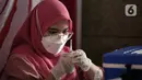Petugas kesehatan menyiapkan vaksin booster COVID-19 di Pasar Tanah Abang Blok A, Jakarta, Senin (4/4/2022). Vaksinasi yang diselenggarakan Polri ini diikuti warga sekitar dan pedagang Pasar Tanah Abang yang berencana mudik Lebaran. (Liputan6.com/Faizal Fanani)