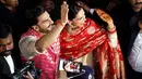 Pasangan pengantin baru, Ranveer Singh dan Deepika Padukone menyapa penggemar yang menyambut mereka di bandara internasional Mumbai, Minggu (18/11). Pasangan bintang Bollywood India itu baru saja kembali dari acara pernikahan mereka di Italia. (AFP)