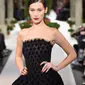 Model Bella Hadid berpose mengenakan gaun hitam koleksi terbaru dari Oscar de la Renta berjalan di atas catwalk selama New York Fashion Week, AS (12/2). Gaun yang dikenakan Bella Hadid dihiasi motif simetris. (AFP Photo/Slaven Vlasic)