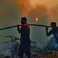 Pemadaman titik kebakaran hutan dan lahan atau karhutla oleh petugas. (Liputan6.com/M Syukur)