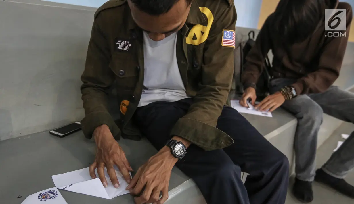 Peserta melipat pesawat kertas pada kompetisi final Red Bull Paper Wings 2019 di Universitas Tarumanagara, Jakarta, Jumat (5/4). Tiga finalis yang lolos mewakili Indonesia ke tingkat dunia pada bulan Mei di Hangar 7, Austria. (Liputan6.com/Fery Pradolo)