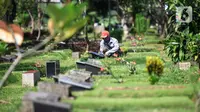 Petugas merawat makam di Tempat Pemakaman Umum (TPU) Karet Bivak, Jakarta, Selasa (11/5/2021). Pemprov DKI akan memberlakukan larangan ziarah kubur Idulfitri di seluruh TPU mulai 12 hingga 16 Mei untuk mencegah terjadinya penyebaran Covid-19 saat berkumpul untuk berziarah. (Liputan6.com/JohanTallo)