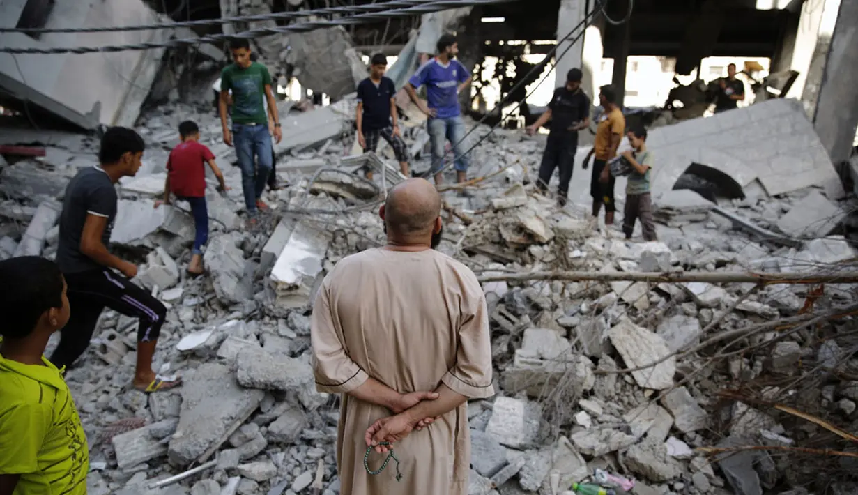 Sejumlah warga berkumpul di reruntuhan sebuah masjid yang hancur pasca serangan udara militer Israel di Gaza, (30/7/2014). (REUTERS/Finbarr O'Reilly)