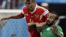 Duel pemain Rusia, Sergei Ignashevich (kiri) dan pemain Arab Saudi, Mohammed Alsahlawi pada laga grup A Piala Dunia 2018 di Luzhniki stadium, Moskow, Rusia, (14/6/2018). Rusia menang 5-0. (AP/Matthias Schrader)