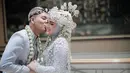 Pasangan muda ini menggelar akan nikah dalah balutan busana adat Sunda berwarna biru muda. Semakin pancarkan pesonanya, Alifhia Fitri sukses bikin pangling hingga dipuji bak barbie. Kebahagiaan yang menyelimuti pasangan ini juga menyelimuti para penggemar yang mengikuti perjalanan cinta mereka sejak awal. Cium pipi Fhia dengan romantis, pasangan muda ini sukses bikin baper. (Liputan6.com/IG/@alifhiafitri)