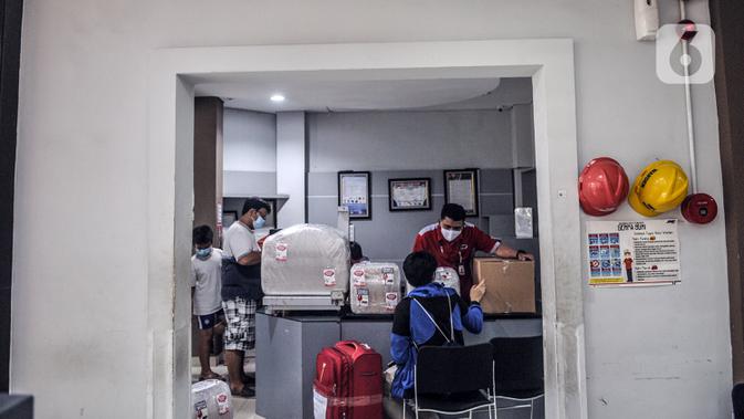 Petugas mengemas barang costumer yang akan dikirim melalui jasa ekspedisi JNE di Tomang, Jakarta, Selasa (29/12/2020). Peningkatan jasa ekspedisi terjadi seiring kian maraknya warga yang membeli barang melalui e-commerce. (merdeka.com/Iqbal S. Nugroho)
