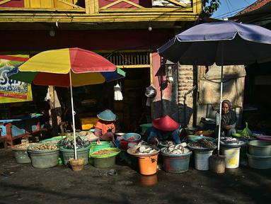 Para pedagang menjual makanan laut segar di sebuah pasar ikan tradisional di Surabaya, Jawa Timur, pada 9 Oktober 2025. (Juni Kriswanto/AFP)