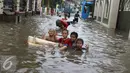  Anak-anak bermain saat banjir menggenangi Jalan Ketapang di kawasan Pasar Minggu, Jakarta, Selasa (4/10). Banjir yang berasal dari luapan Kali Anur tersebut menyebabkan Jalan Ketapang tidak bisa dilewati kendaraan. (Liputan6.com/Immanuel Antonius)