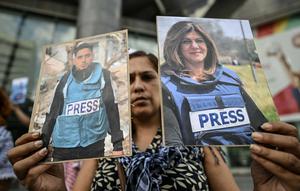 Sejumlah warga Palestina turut berduka atas kematian jurnalis tersebut. Tampak dalam foto, seorang pekerja media pemerintah memegang potret jurnalis Palestina yang telah meninggal selama demonstrasi di depan gedung PBB di Caracas pada 11 Agustus 2025. (Juan BARRETO/AFP)