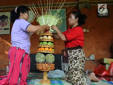 Sejumlah ibu serati banten mempersiapkan Gebogan yang akan digunakan dalam upacara Mecaru dalam menyambut perayaan hari Raya Nyepi dan Tahun baru Saka 1941 di Pura Tribhuana Agung Sukmajaya Depok, Jawa Barat, Selasa (5/3). (Liputan6.com/Herman Zakharia)