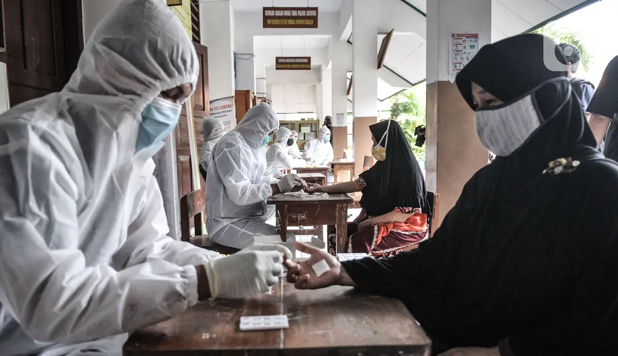 Warga saat mengikuti rapid test di SDN 01 Petamburan, Jakarta, Minggu (22/11/2020). Rapid test gratis ini digelar setelah ditemukannya kasus positif beberapa warga seusai menghadiri peringatan Maulid Nabi dan pernikahan putri Rizieq Shihab beberapa waktu lalu. (merdeka.com/Iqbal S. Nugroho)