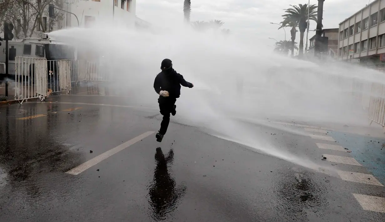 Polisi terpaksa menanggapi aksi kekerasan ini dengan meriam air. (AP Photo/Luis Hidalgo)