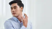 Seorang pria sedang menyemprotkan parfum. (DragonImages/https://depositphotos.com)